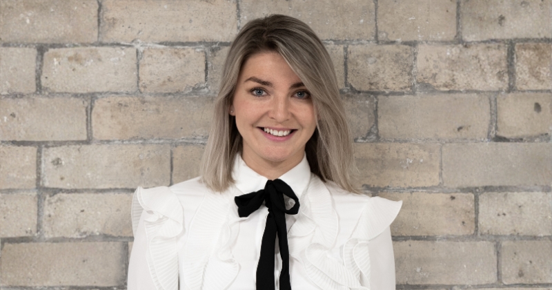Headshot of Aileen Edmunds, Longleigh's new CEO wearing a white blouse, with a black knotted tie. Aileen is smiling and looking directly at the camera.