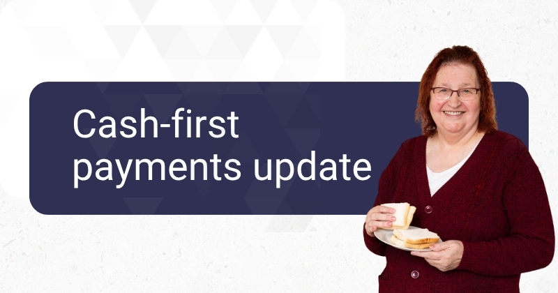 Promotional graphic for a cash-first payments update. The words “Cash-first payments update” appear in large white text on a dark blue panel, alongside a person holding a plate with slices of bread.